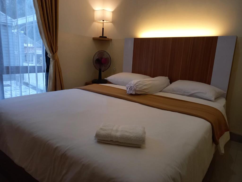 a bedroom with a large bed with a towel on it at Villa Bandungan, Semarang in Bandungan