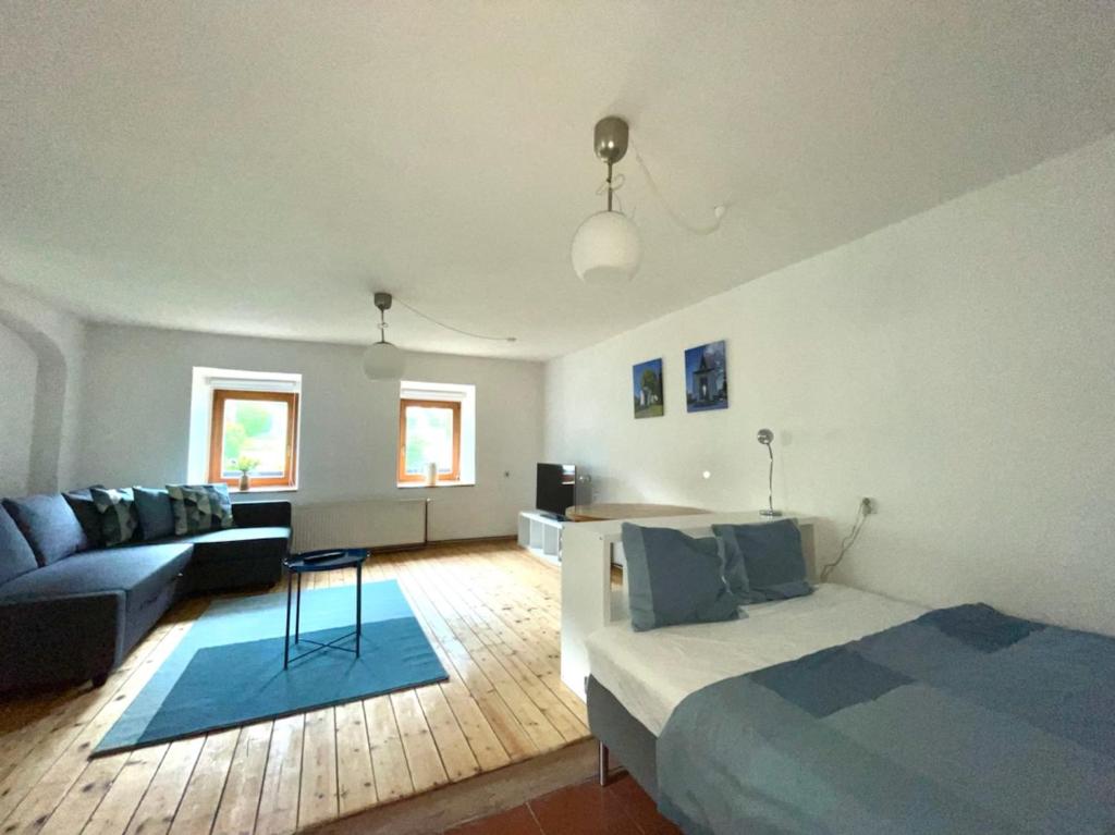 - un salon avec un lit et un canapé dans l'établissement Bílka 33 - Village home in the Czech Central Highlands, à Bořislav