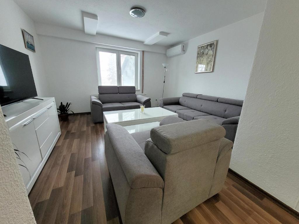 a living room with a couch and a tv at Apartman Studenac in Kiseljak