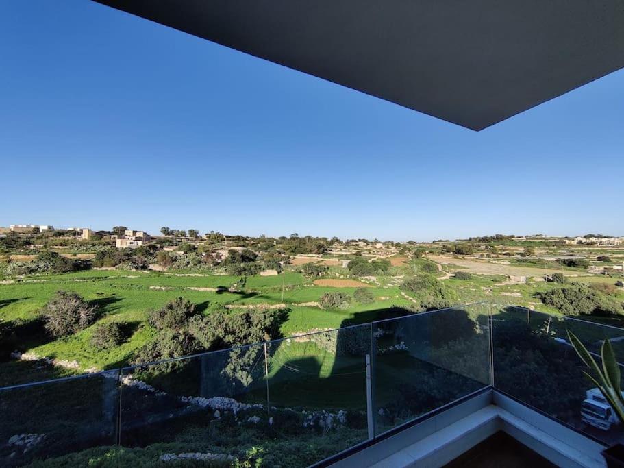 uma vista para um campo de golfe a partir da varanda de uma casa em Luxurious 2 bedroom apartment with country view em Marsaxlokk