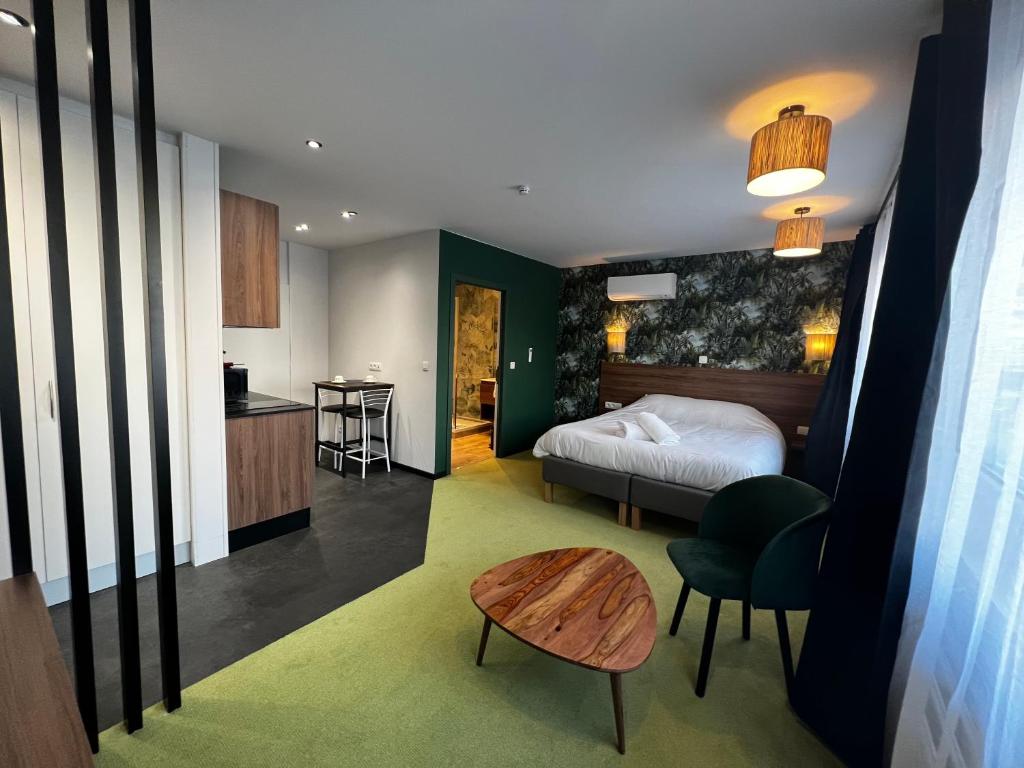 een slaapkamer met een bed en een tafel en een keuken bij DayNight Sauveniere in Luik