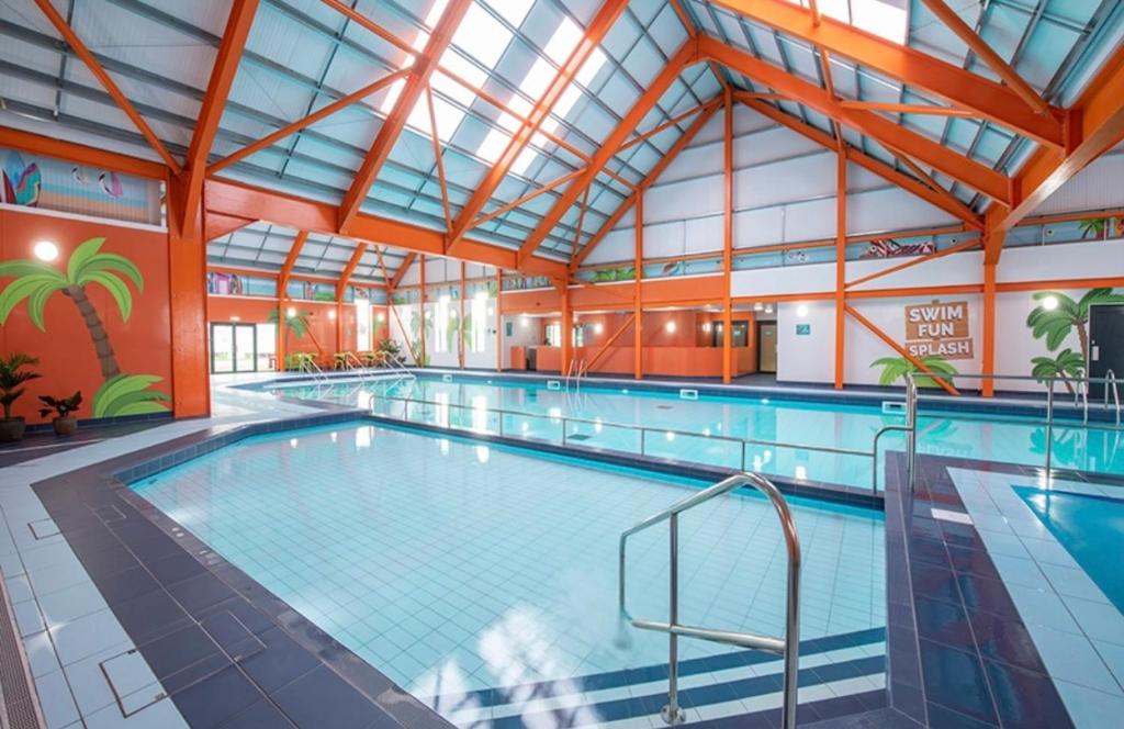 a large indoor swimming pool with a large ceiling at 8 Berth Holiday Home with Pools on Martello Beach in Jaywick Sands