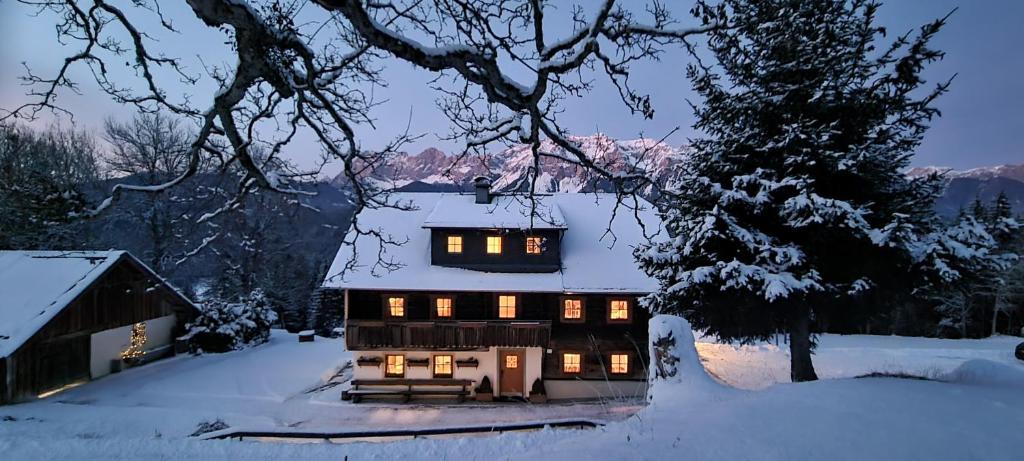 a house with lights on in the snow at Selbstversorgerhaus Herisch in Schladming