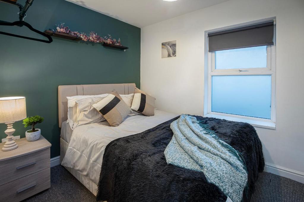 um quarto com uma cama e uma janela em Bank Street Apartment 4 em Blackpool