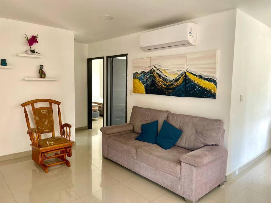 a living room with a couch and a painting on the wall at Apartamento en el epicentro del Carnaval in Barranquilla