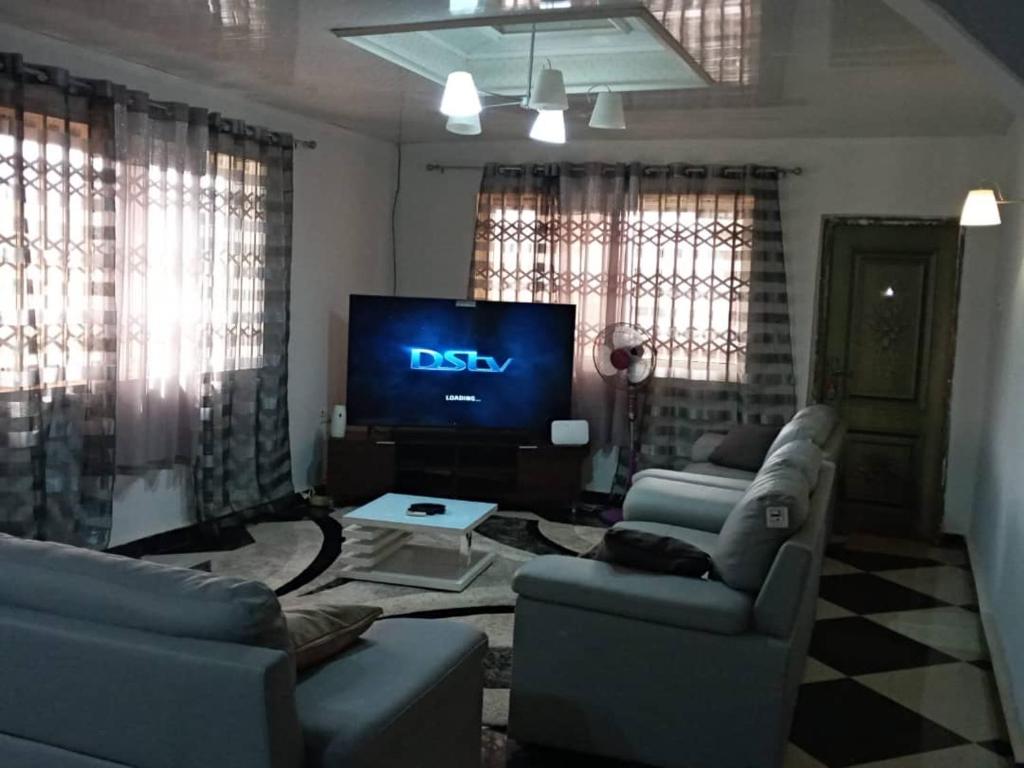 sala de estar con 2 sofás y TV en Well presented apartment with 2 master bedrooms. en Freetown