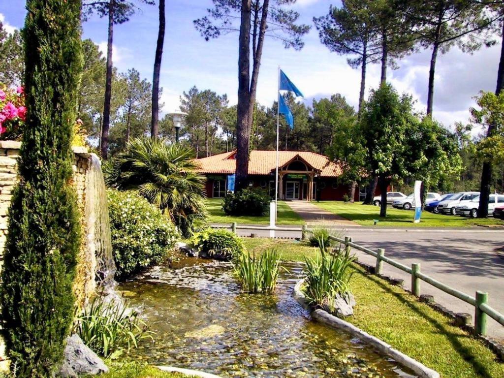 a garden with a pond in front of a house at MOBIL HOME Tendance Tout Confort - FUNPASS non included in Gastes