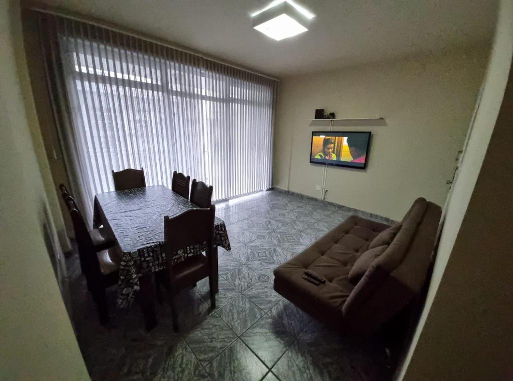 een woonkamer met een bank en een tafel bij Apto Praia Gonzaga - melhor localização in Santos