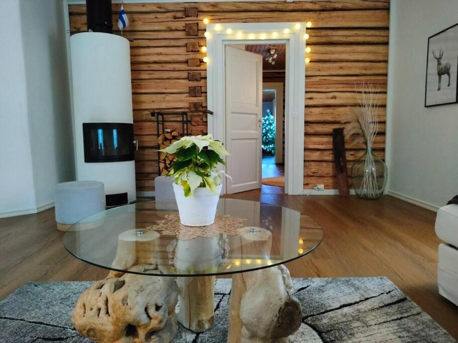 uma sala de estar com uma mesa de vidro com um vaso de plantas em Villa Tiiro em Ii