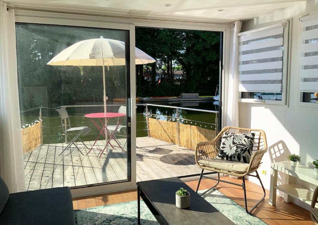 a screened in porch with a chair and an umbrella at Bateau appartement sur l'Erdre au coeur de Nantes in Nantes