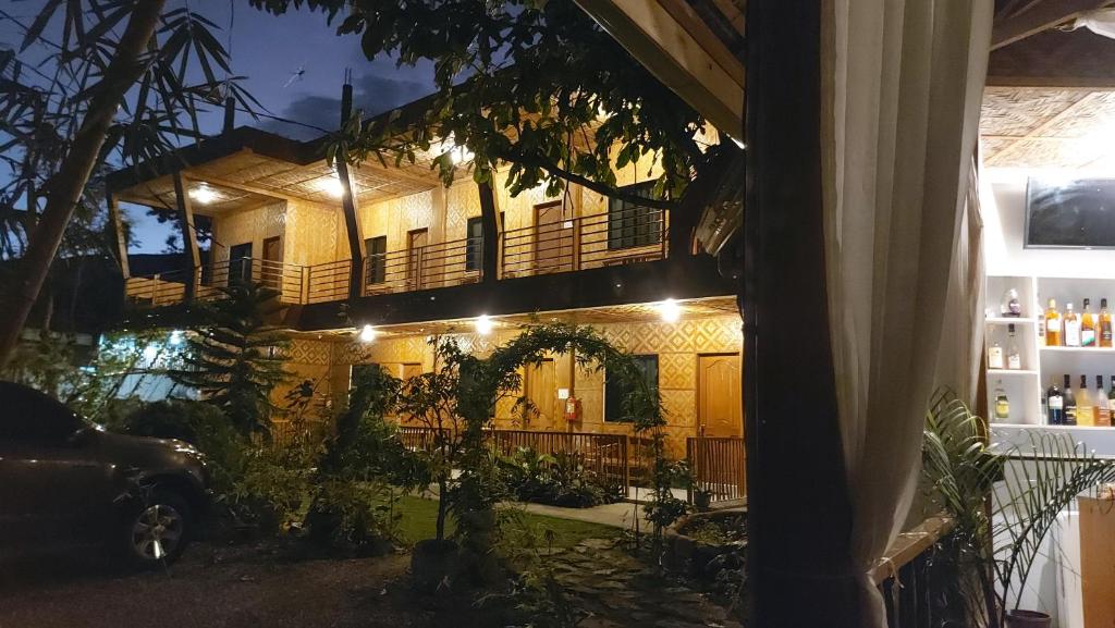 a house with a balcony at night at New Village Lodge in Oslob
