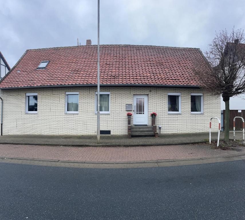 una casa de ladrillo blanco con techo rojo en Gasthaus Katrin en Königslutter am Elm
