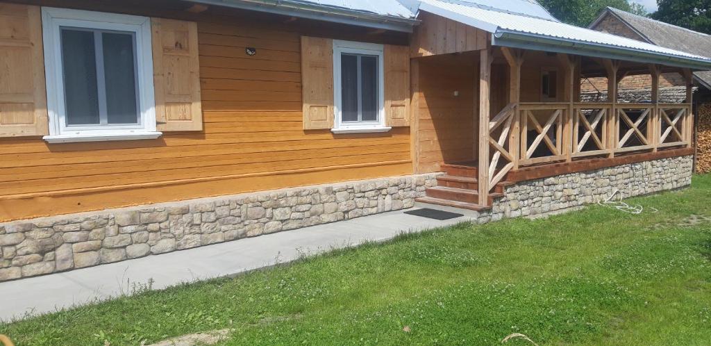 uma casa de madeira com uma parede de pedra em Dom Na Wsi u Ani em Koszele