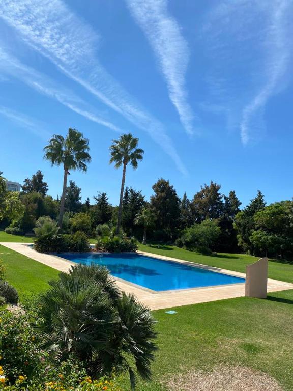 a swimming pool with palm trees in a park at Balaia Residence in Albufeira