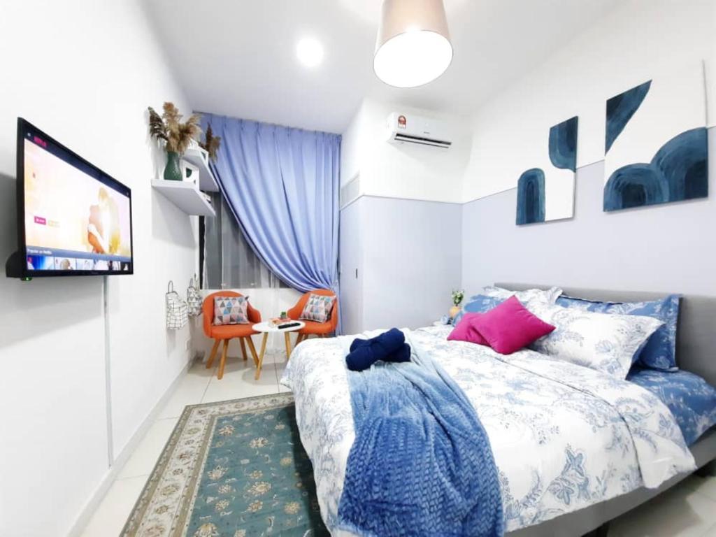 1 dormitorio con 1 cama azul y blanca y TV en Horizon Suites, KLIA, en Sepang