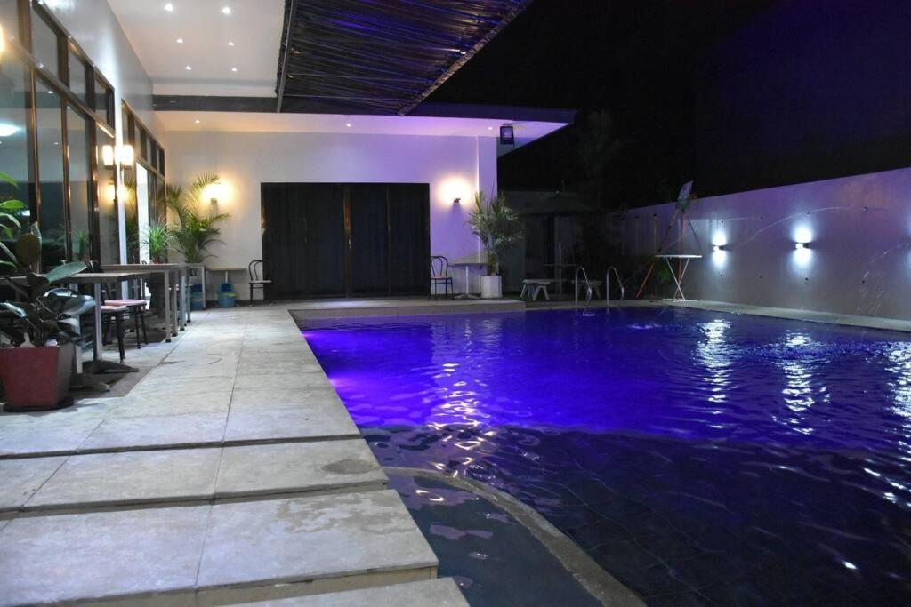 a swimming pool with purple lights in a building at Lovely 2-bedroom hotspring resort in Calamba