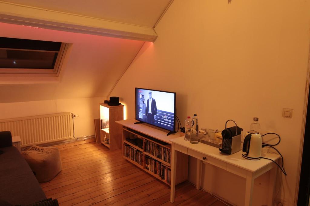 a living room with a television on a table at Serbie 21 in Brussels