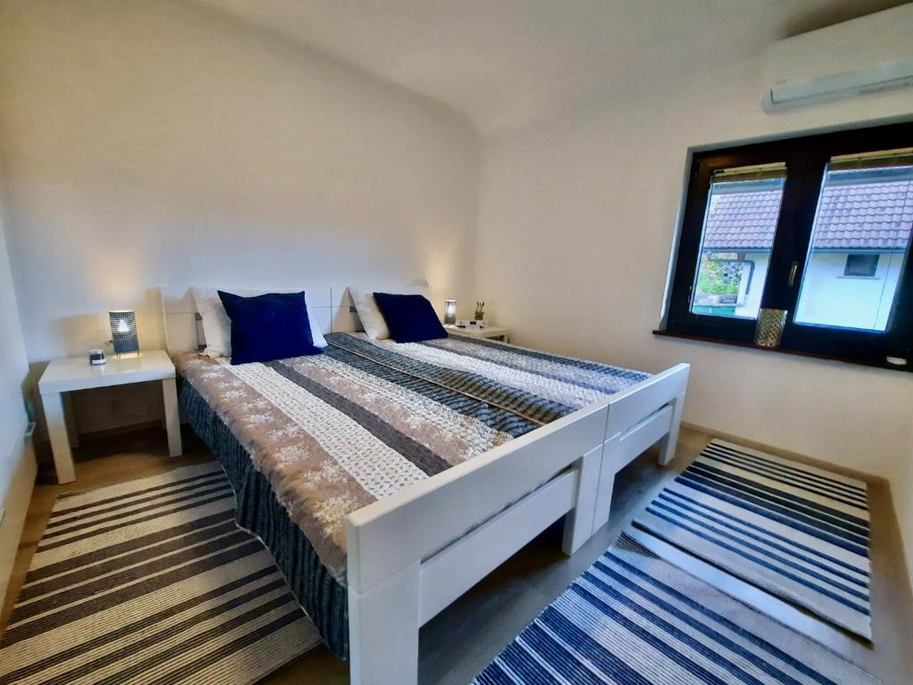 Un dormitorio con una cama grande y una ventana en Vineyard cottage Kulovec, en Uršna Sela