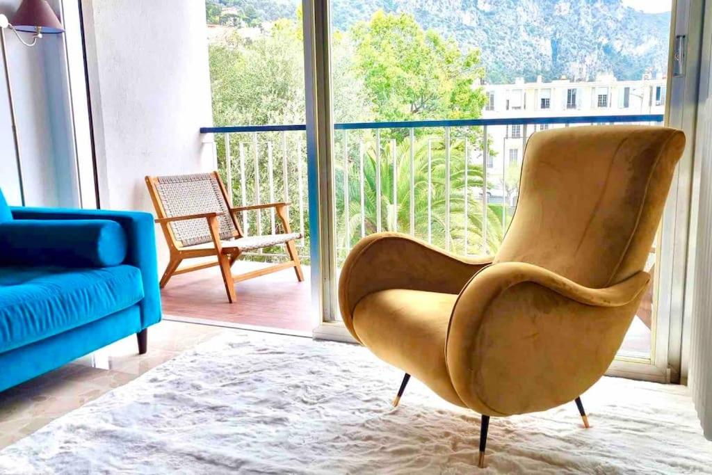 a living room with a blue couch and a chair at Central, quiet & cosy apartment near Monaco in Beaulieu-sur-Mer