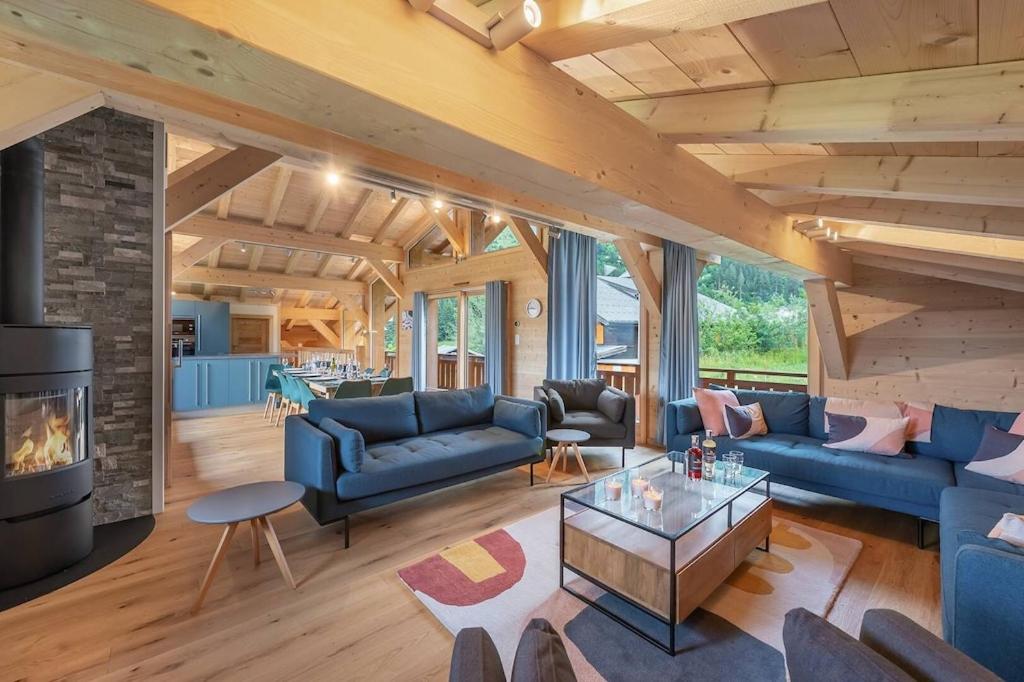 a living room with blue couches and a fireplace at Chalet de Vonnes - Apt 10 - BO Immobilier in Châtel