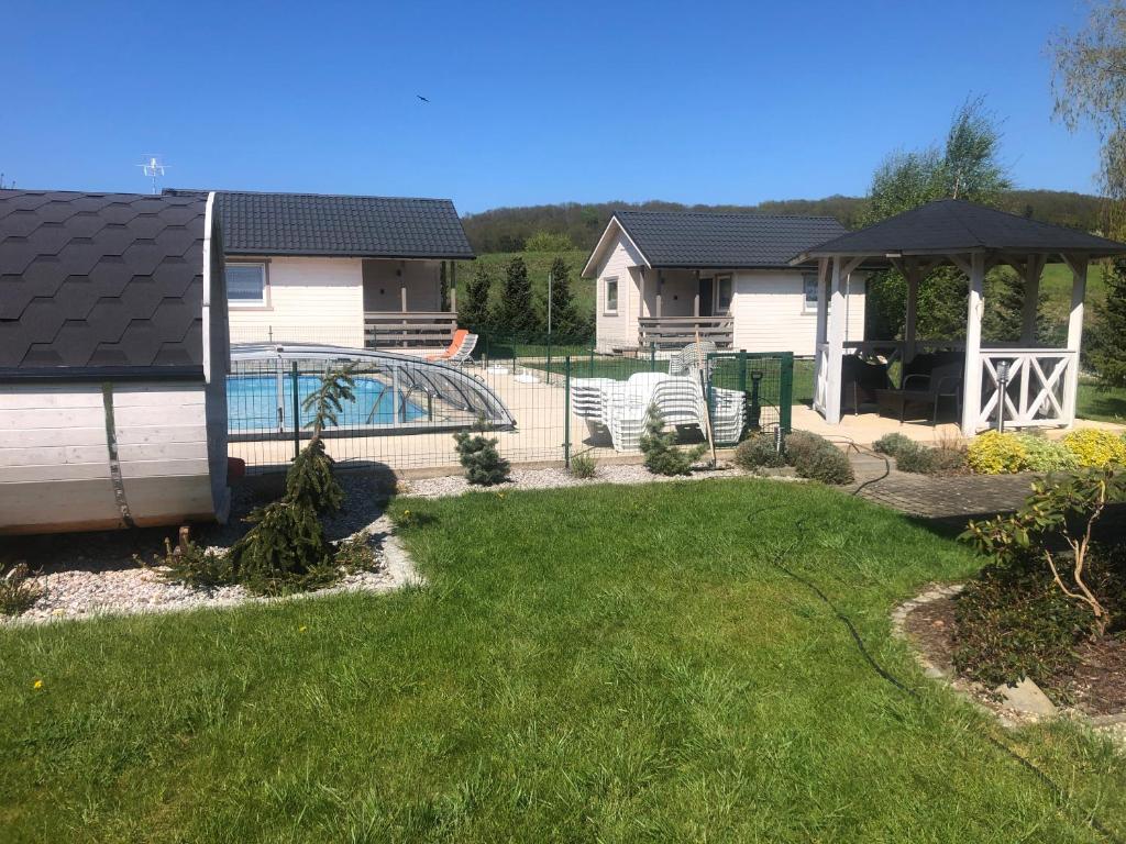 a backyard with a pool and a house at Dolina Wisełka in Wisełka
