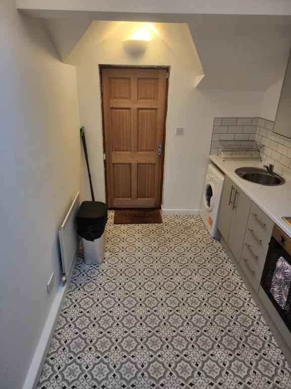 an empty kitchen with a sink and a door at 205a Monton Road in Manchester