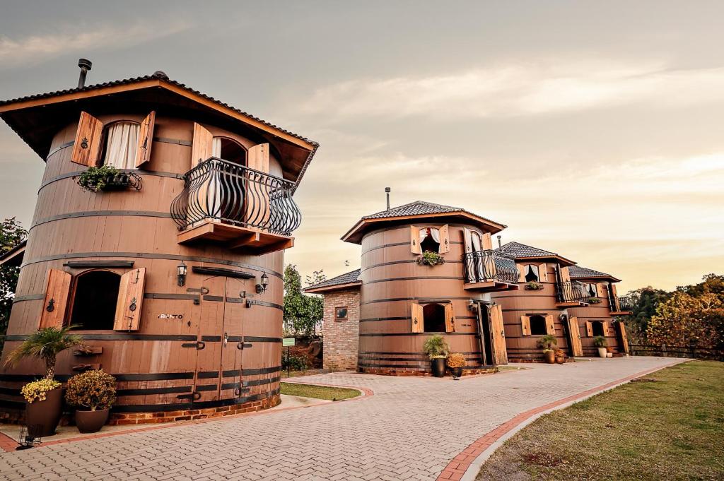 um edifício com um silo ao lado de uma casa em Pipas Terroir - Vale dos Vinhedos - Pousada Temática em Bento Gonçalves