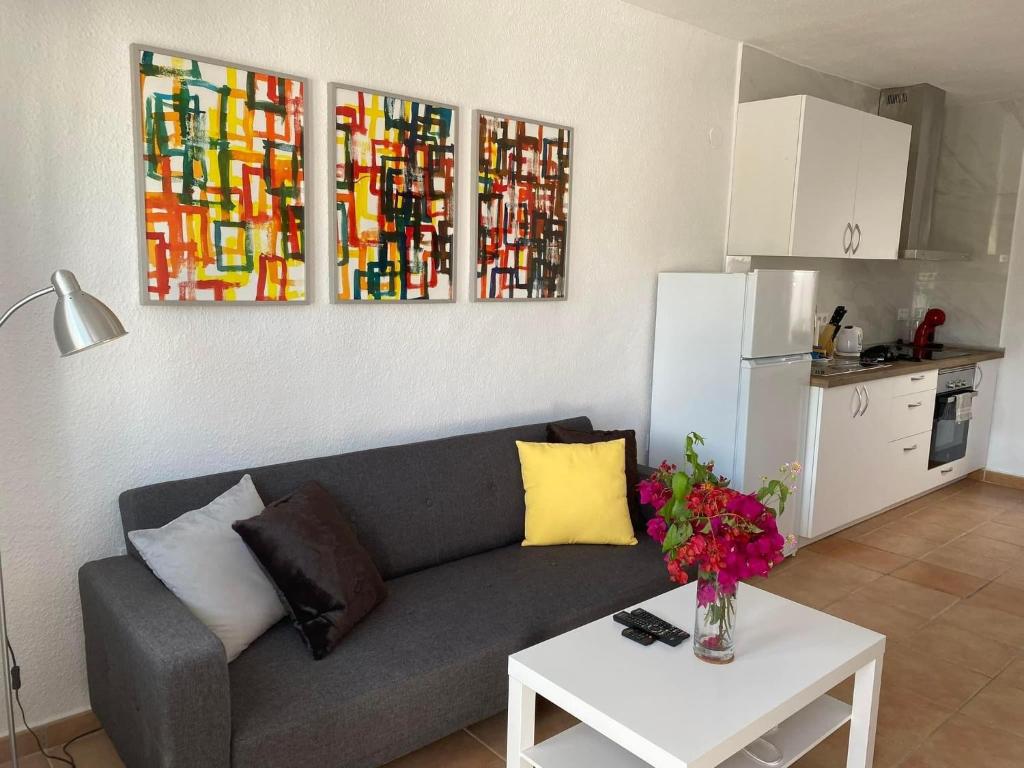 un soggiorno con divano e tavolo con fiori di Modern and airy holiday home a Torrevieja