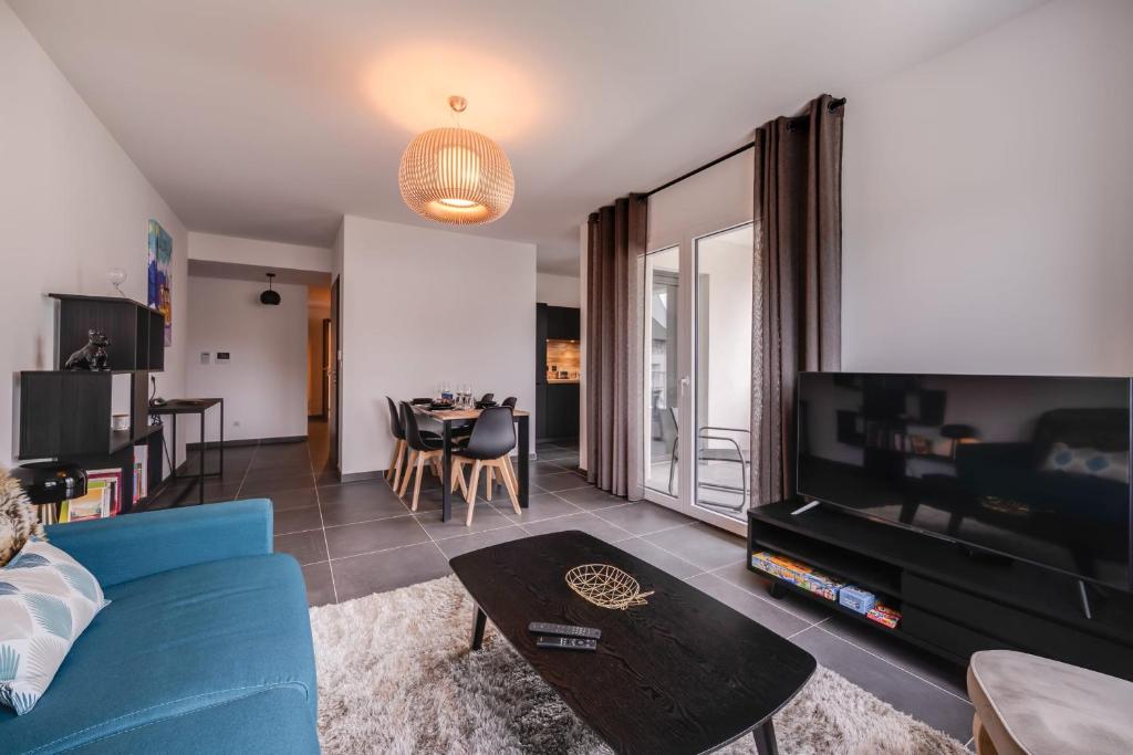 a living room with a blue couch and a table at Le 305 - T3 with garage and beautiful terrace in Annecy
