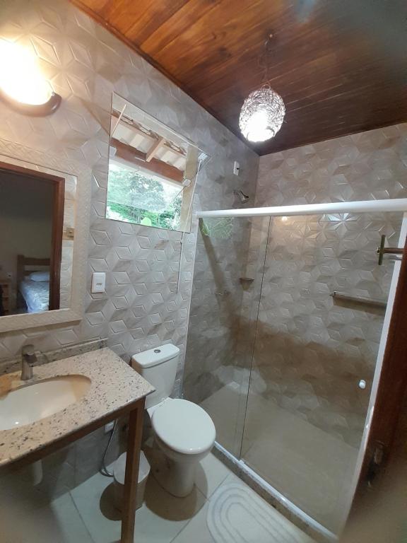 uma casa de banho com um chuveiro, um WC e um lavatório. em Namata CHALÉS em Nova Friburgo