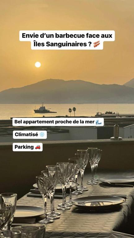 - une table avec des verres à vin et l'océan en arrière-plan dans l'établissement Superbe T2 climatisé, proche plage - belle vue mer, à Porticcio