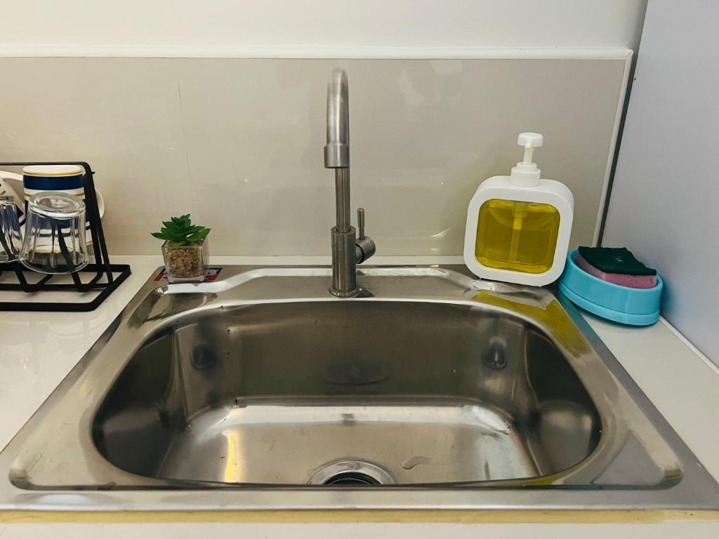 a sink with a faucet in a kitchen at Condo Staycation at Valenzuela I Studio type in Manila