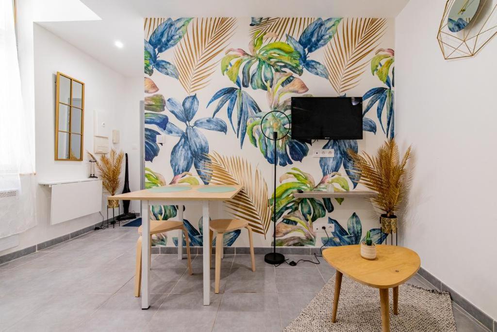 a room with a wall with a mural of leaves w obiekcie Studio cosy au coeur de l'Ecusson - Arènes à 2 min w mieście Nîmes