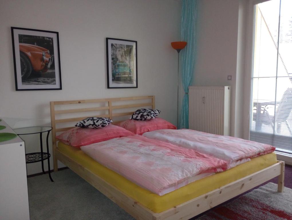 um quarto com 2 camas e almofadas cor-de-rosa em Apartmán Rezidence Čertovka 2121 free parking garage em Karlovy Vary