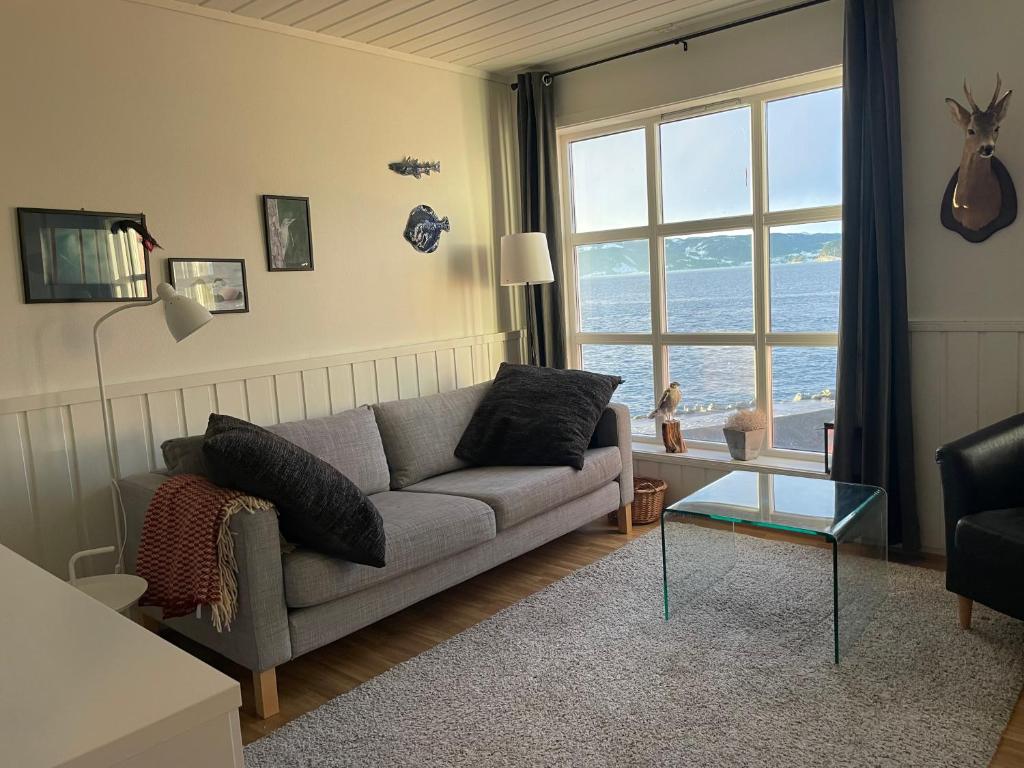 a living room with a couch and a large window at Spacious apartment with view over the trondheimfjord in Vangshylla
