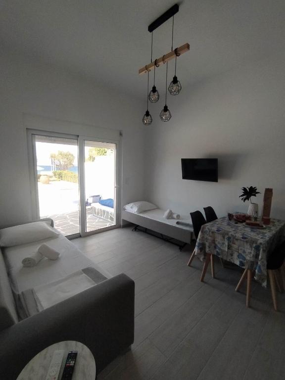 salon z kanapą i stołem w obiekcie Enigma Boutique Houses Votsalo w mieście Marmari