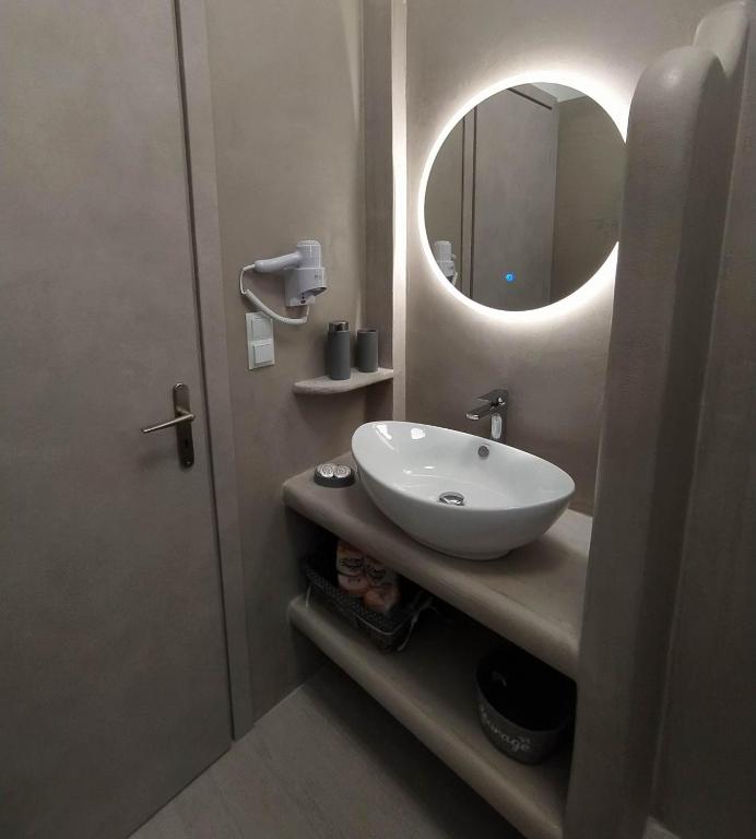łazienka z umywalką i lustrem w obiekcie Enigma Boutique Houses Votsalo w mieście Marmari