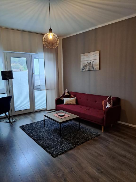 sala de estar con sofá rojo y mesa en Aulbach' s Appartments, en Leidersbach