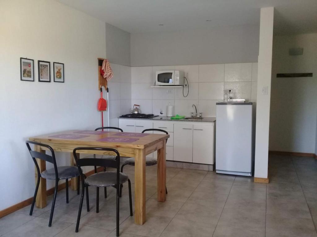 a kitchen with a table and chairs and a refrigerator at Casas Tomillo Silvestre in Sierra de la Ventana