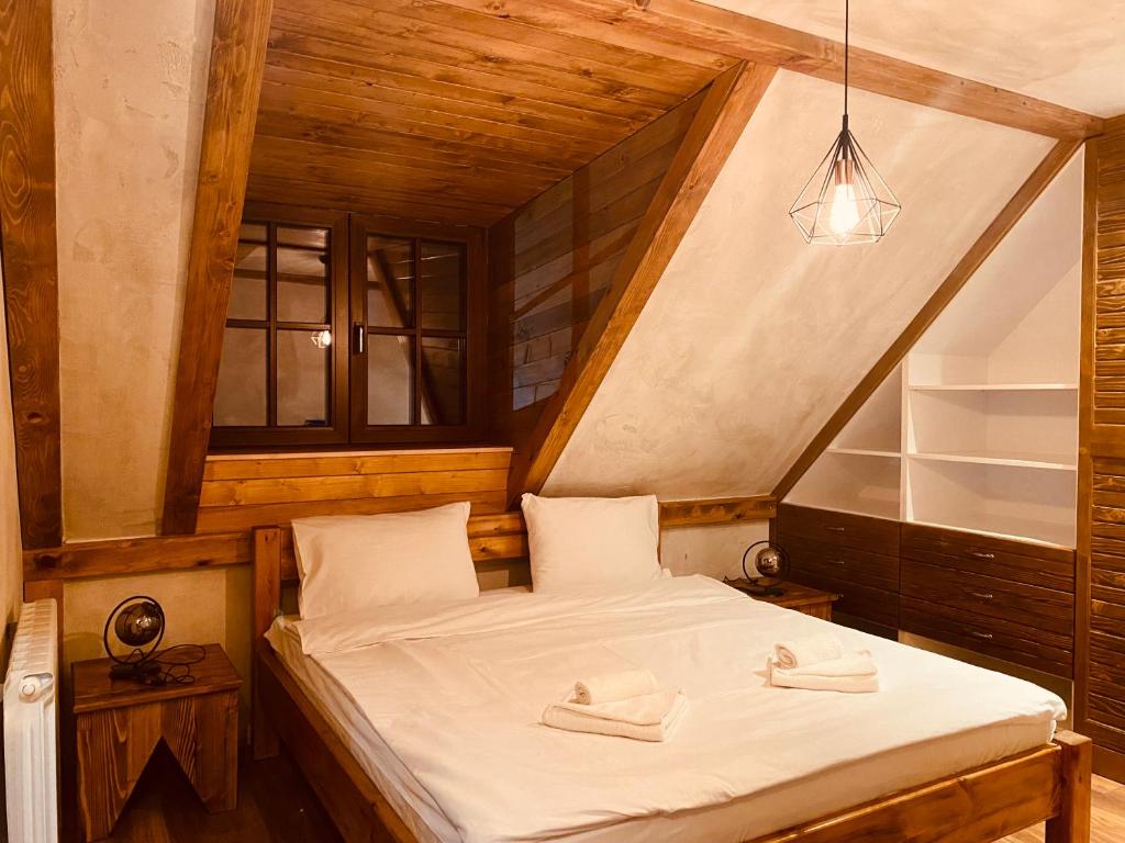 a small bedroom with a bed in a attic at ETNO SELO VRANEŠA Zlatar in Nova Varoš