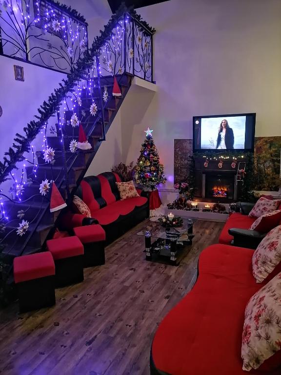 a living room with a christmas tree and a staircase at Pensiunea Melissa in Măceşu de Jos