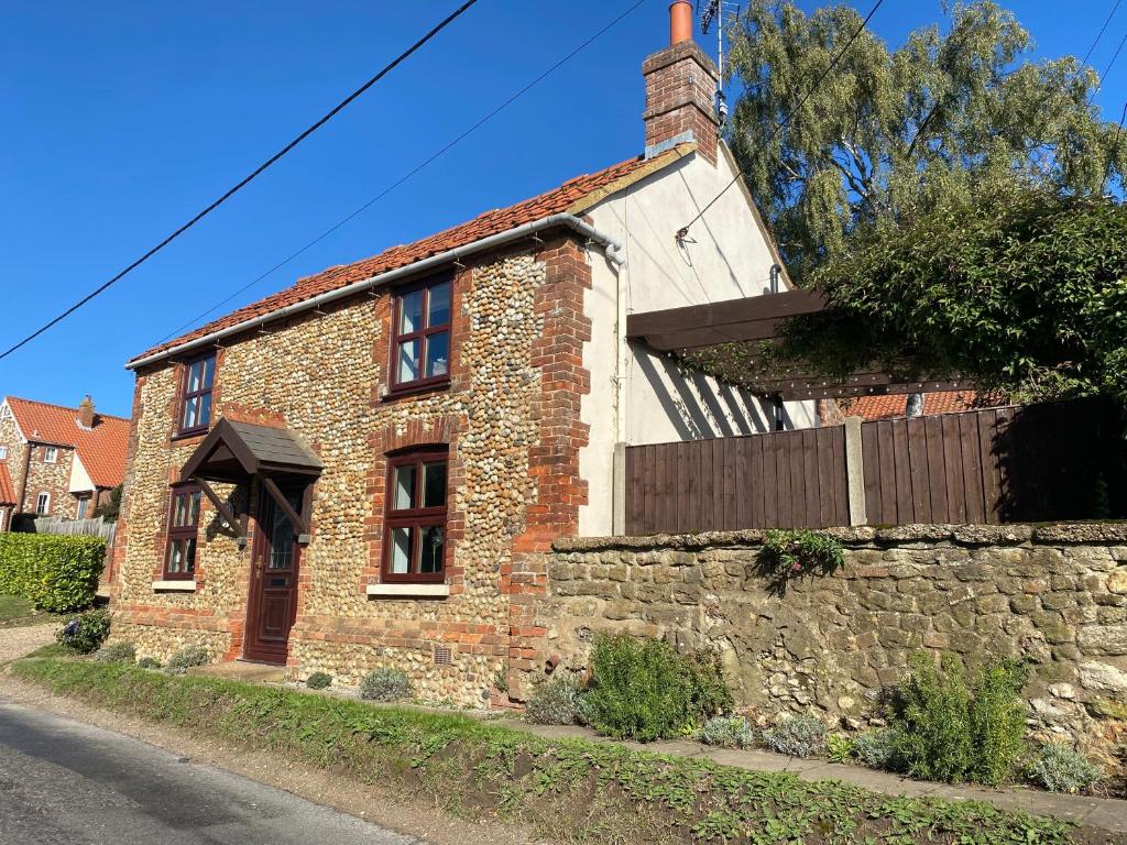 an old brick house on the side of a street at Curlew Cottage in Sedgeford