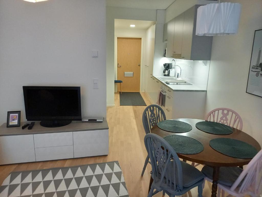 a kitchen and a dining room with a table and chairs at New&Easy apartment in the center in Turku
