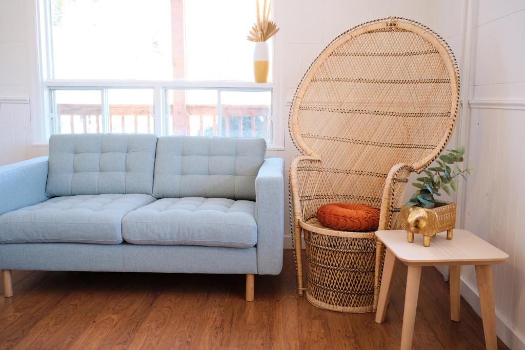 a living room with a blue couch and a large mirror at AUBERGE DU DIMANCHE - Hôtel Pres du Fjord-du-Saguenay et de l'Anse-Saint-Jean in Riviere Eternite