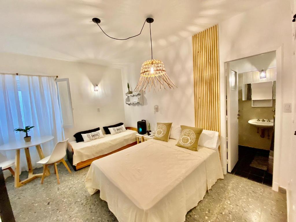 1 dormitorio con 2 camas, mesa y lámpara de araña en Departamento 1 ambiente Mar del plata en Mar del Plata