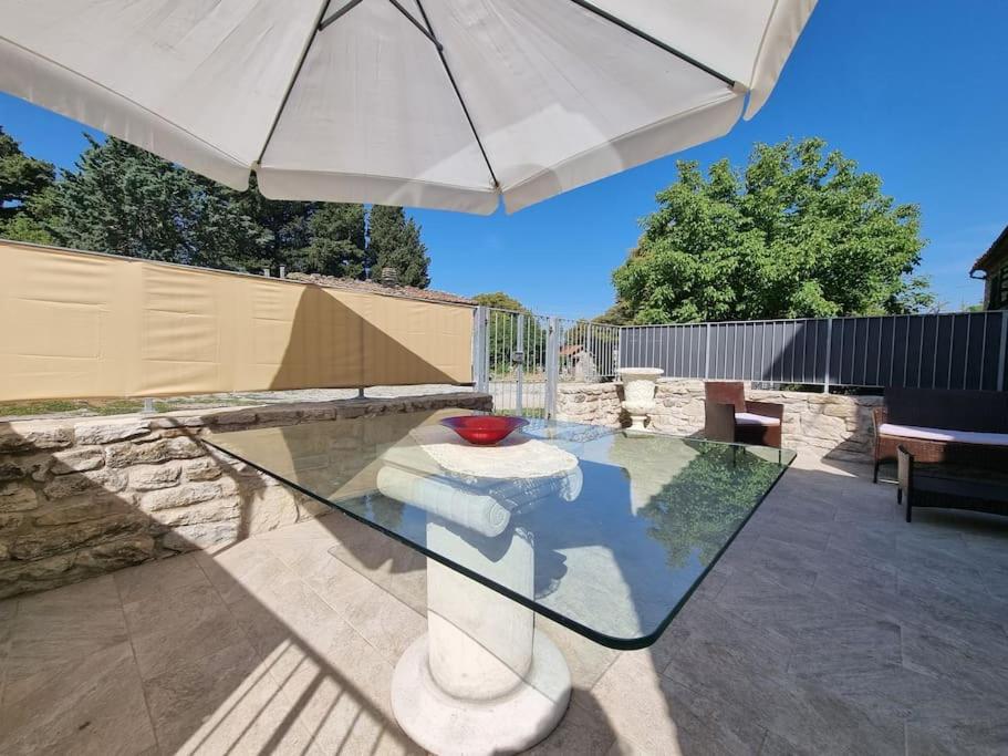 einen Glastisch mit einem weißen Regenschirm auf einer Terrasse in der Unterkunft Il casale del Domo in Monsummano