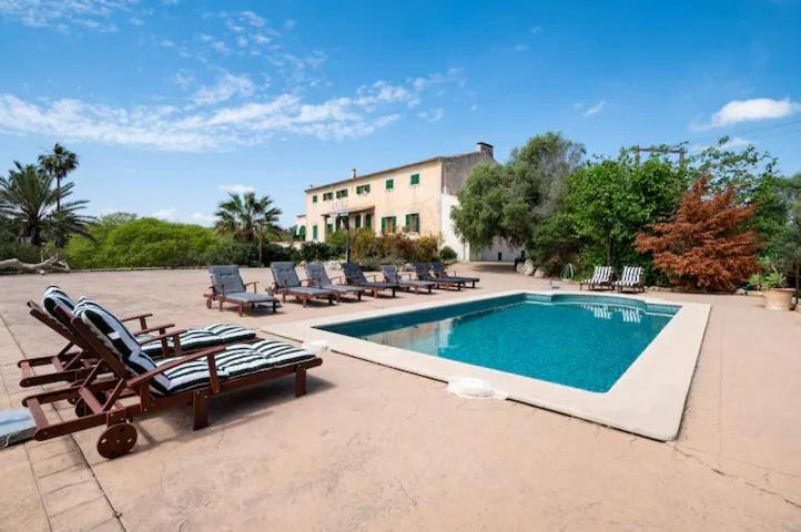 a swimming pool with lounge chairs and a house at Agroturismo Son Sant Andreu in Petra