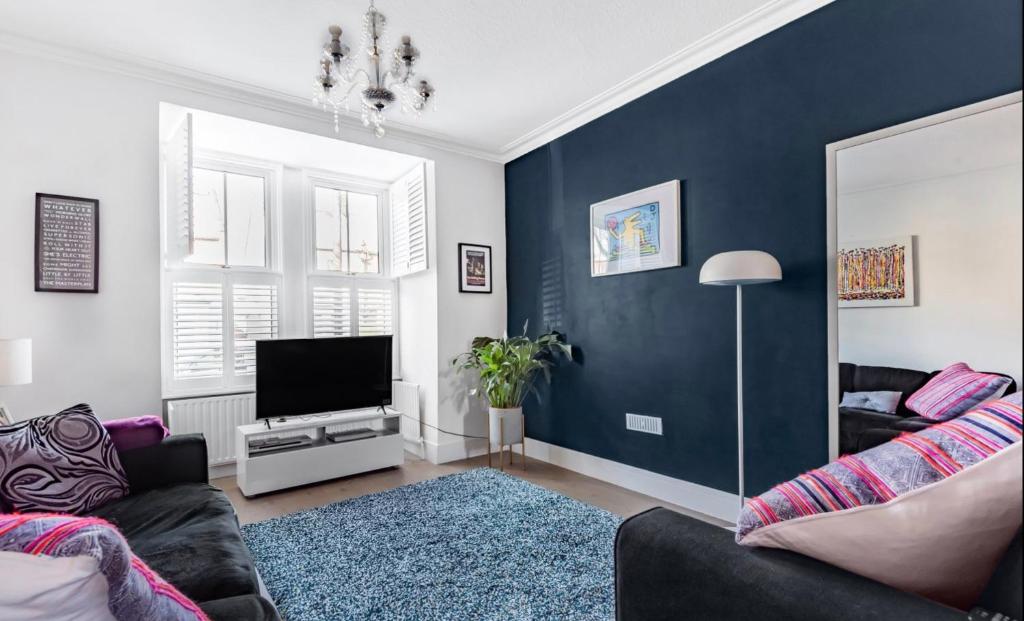 a living room with a couch and a tv at Inviting 3-Bed House in Beckenham in Beckenham