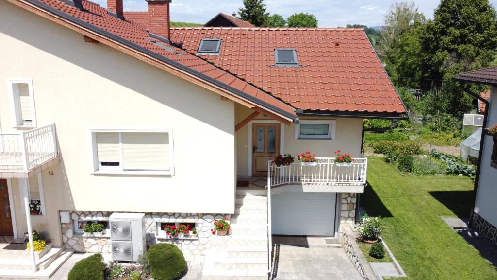 een wit huis met een balkon met bloemen erop bij Apartment Venko in Slovenske Konjice