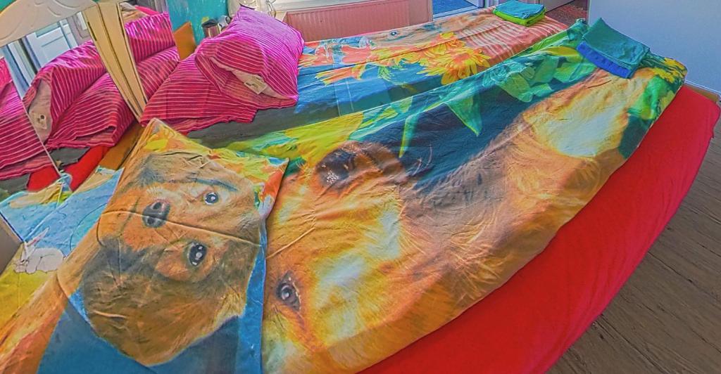 Una cama con una manta de colores encima. en Helsinki Private-Yksityinen-Частный Room in Shared Apartment into Airport-BusTrain Station-University, en Helsinki